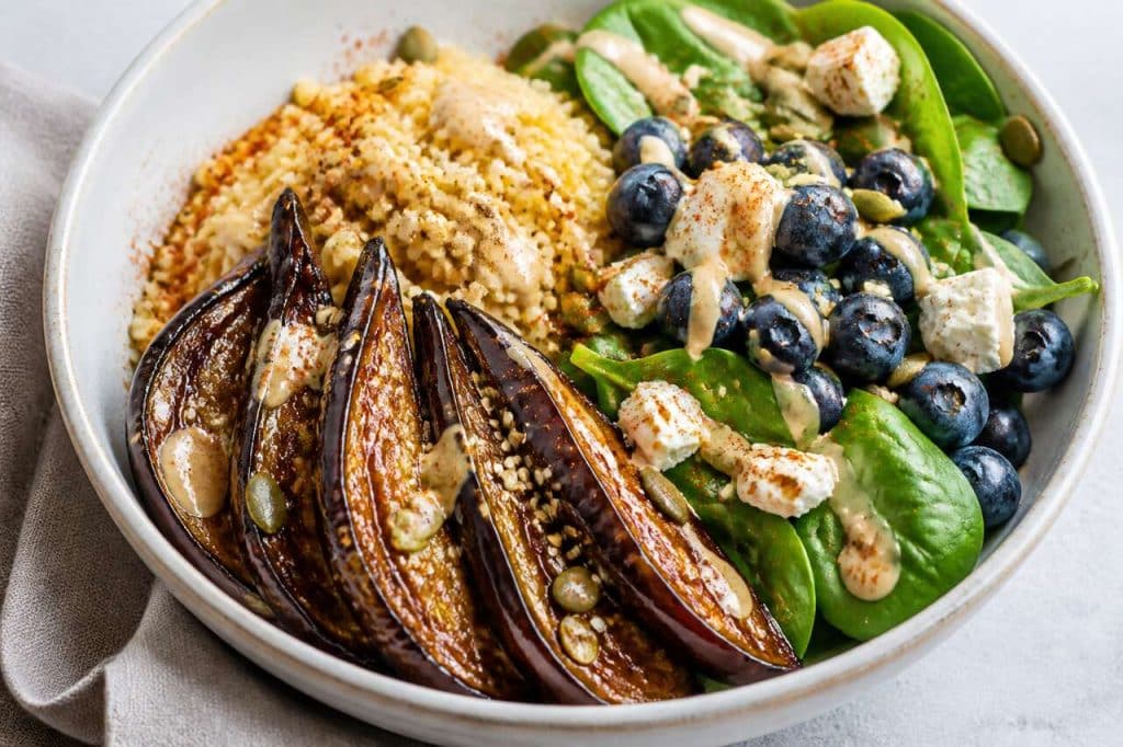 Buddha bowl d'aubergine rôtie au sirop d'érable, boulgour, épinards, feta et myrtilles